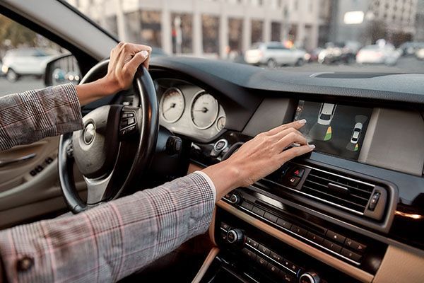 Driver in car, using touch screen. Close up of hands on screen and steering wheel. | Dave's Automotive LLC