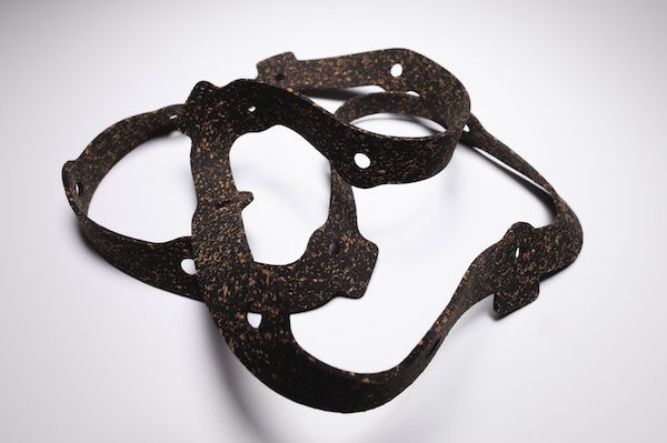Dark brown, intricately shaped, leather-like object with holes, likely part of a harness or similar gear, against white. | Dave's Automotive LLC
