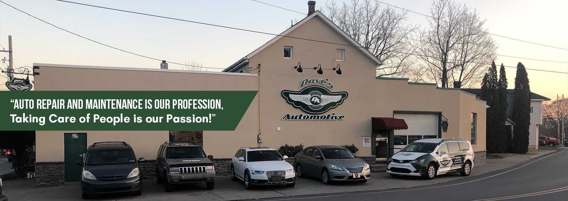 Cars parked in front of an auto repair shop with a green banner and logo on the building. | Dave's Automotive LLC