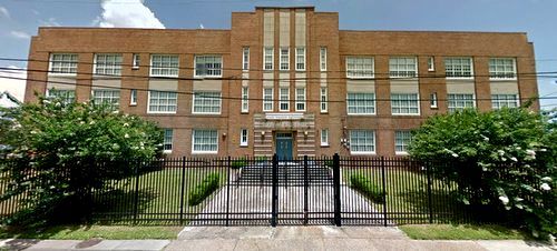 a large brick building with a fence around it .