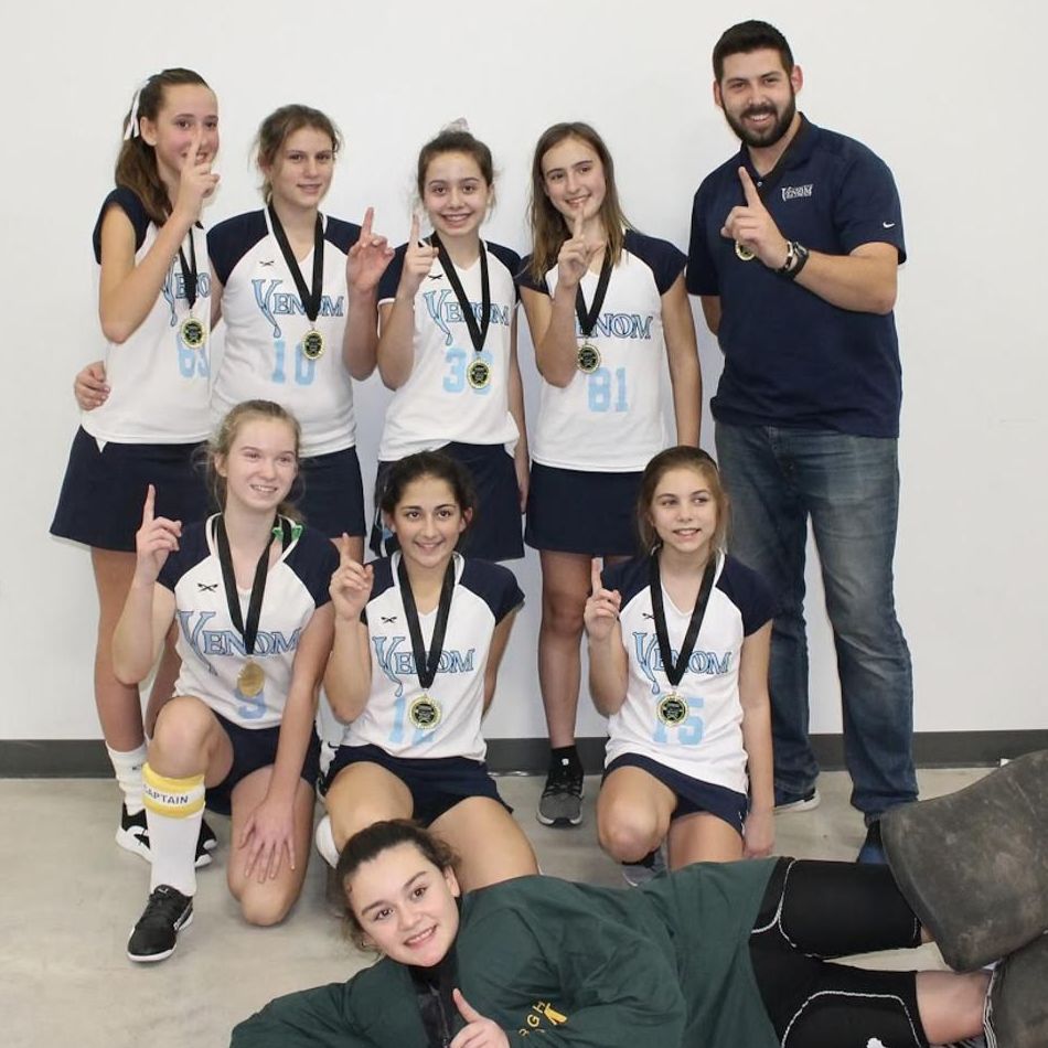 A group of young girls are posing for a picture with medals around their necks