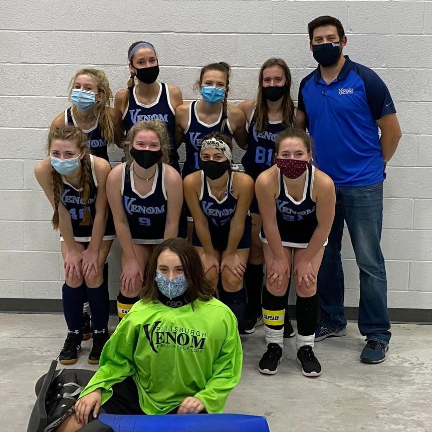 A group of female athletes wearing masks are posing for a picture.