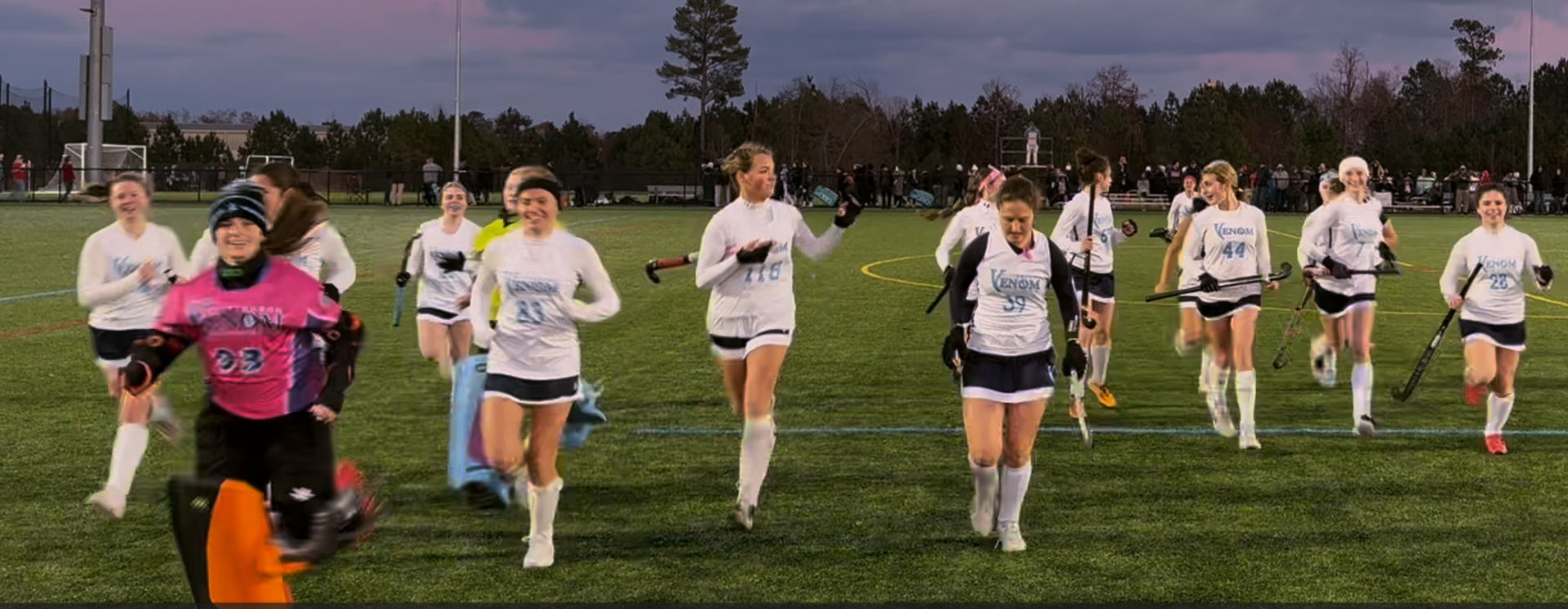 A field hockey player wearing a jersey that says ' kensington ' on it