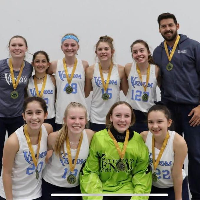 A group of young girls wearing venom jerseys pose for a picture