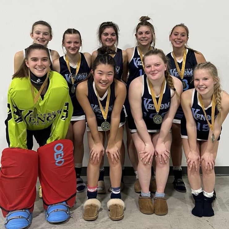 A group of young girls are posing for a picture with medals around their necks.