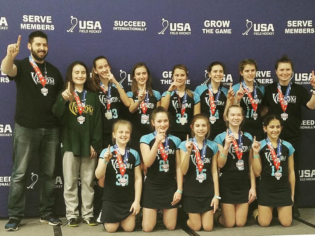 A group of athletes posing for a picture with a banner behind them that says serve members