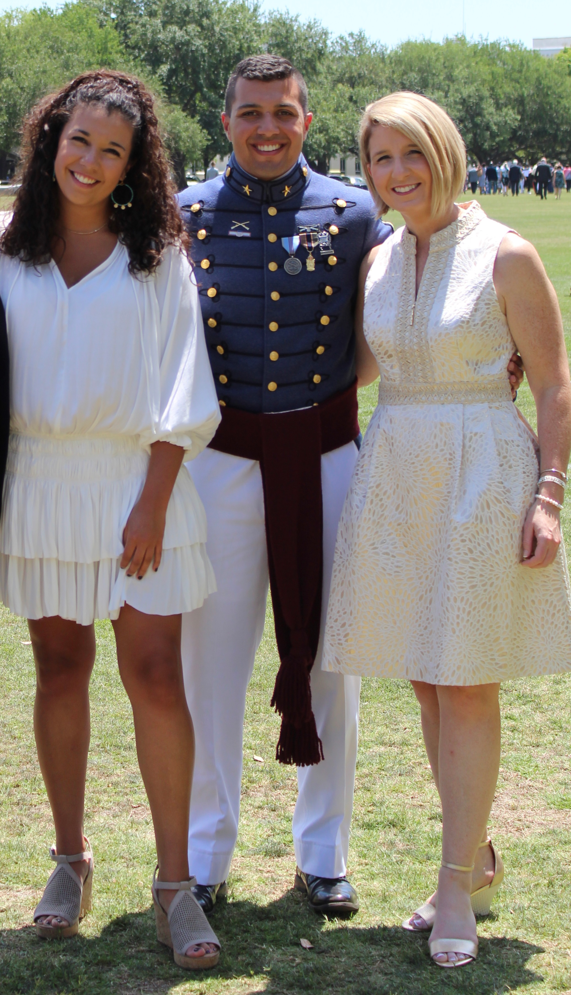 A man in a military uniform is posing for a picture with two women.