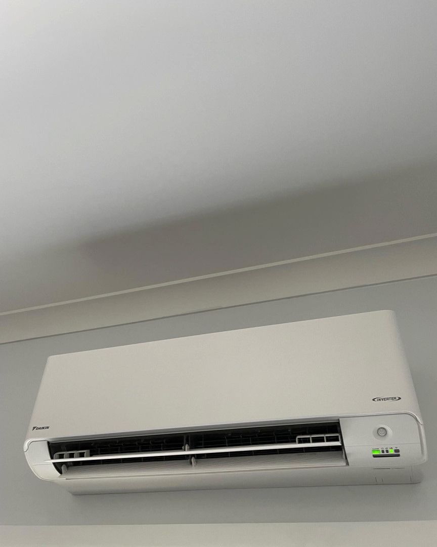 White Wall-mounted Air Conditioner Unit on a Light Gray Wall, Shown Close-up — Deltech HVACR in Cessnock, NSW