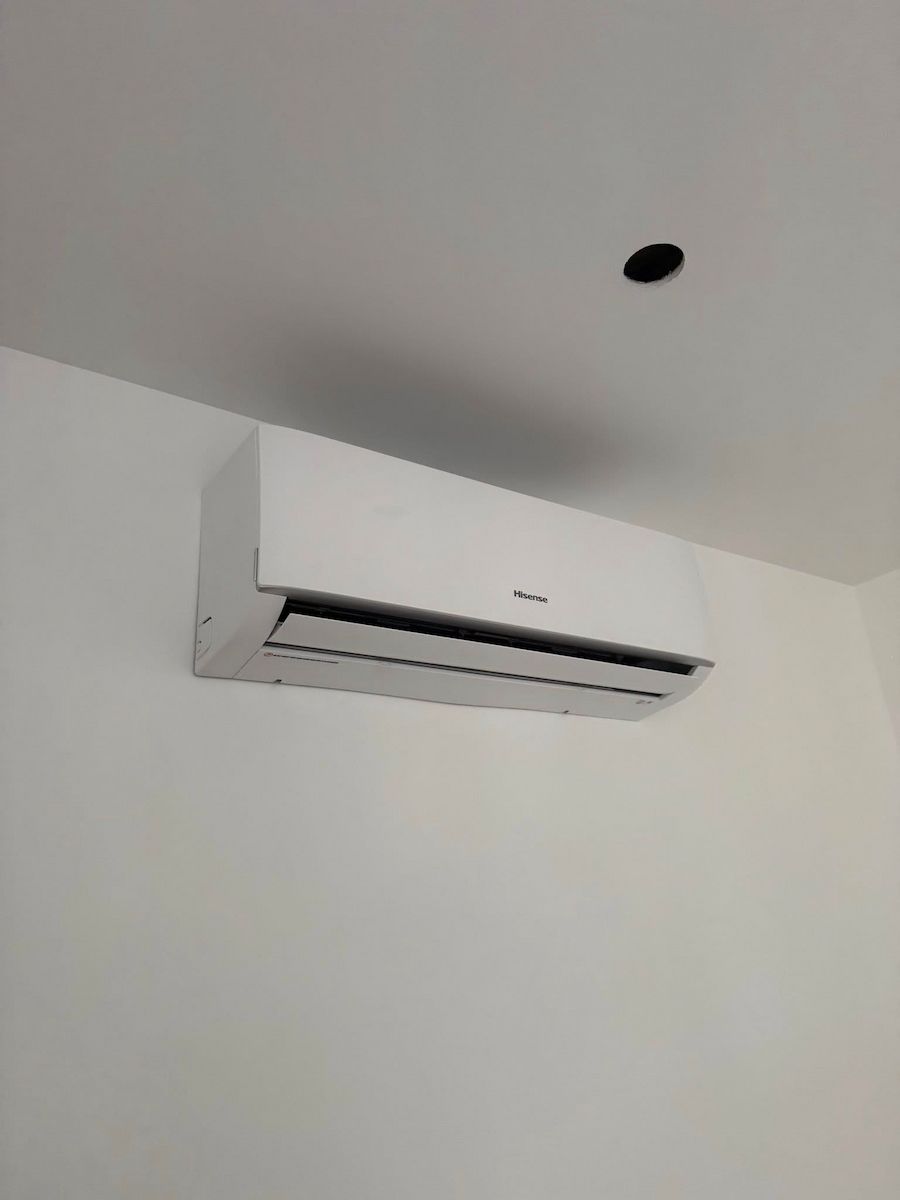 Wall-mounted White Air Conditioner on a Plain White Wall — Deltech HVACR in Central Coast, NSW