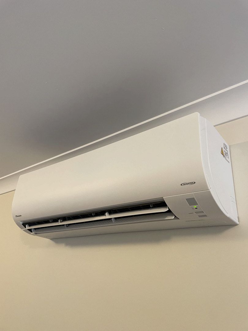 White Wall-mounted Air Conditioner Near the Ceiling on a Beige Wall — Deltech HVACR in Lake Macquarie, NSW