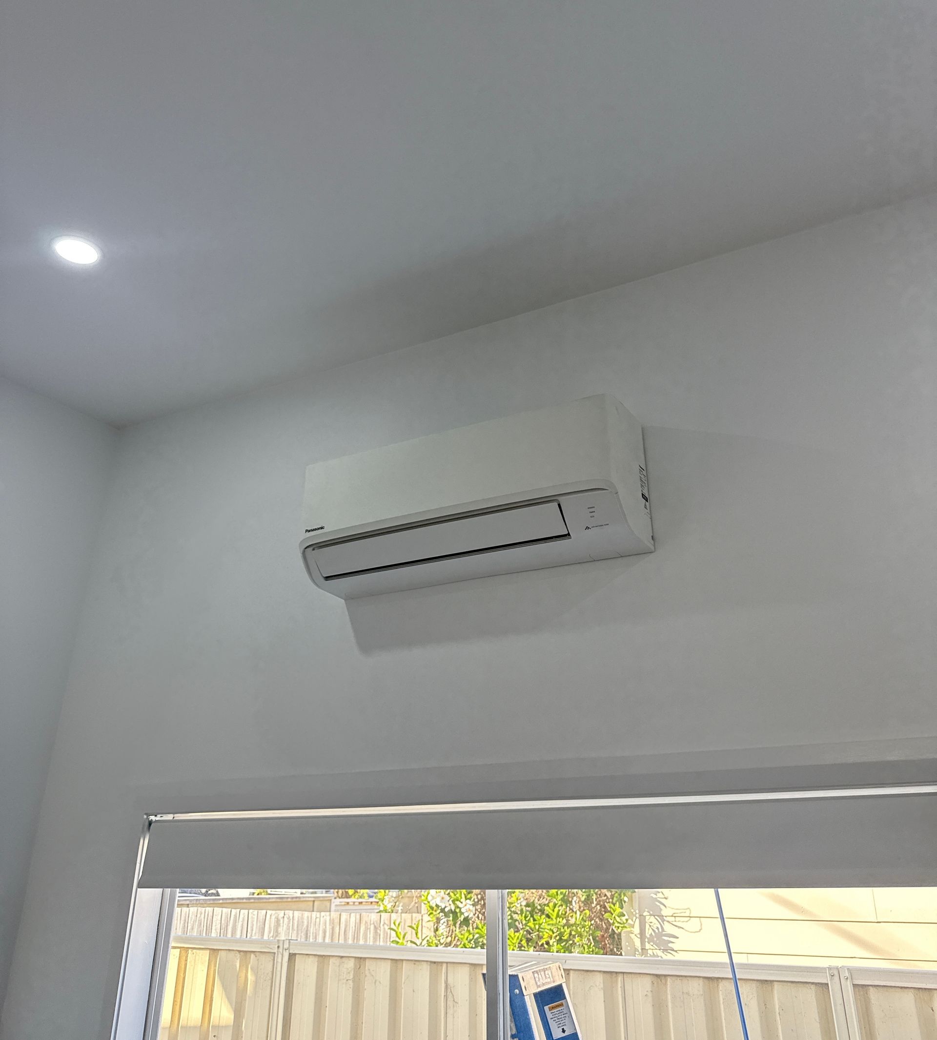 White wall-mounted air conditioner above a window in a bright room  — Deltech HVACR in Georgetown, NSW