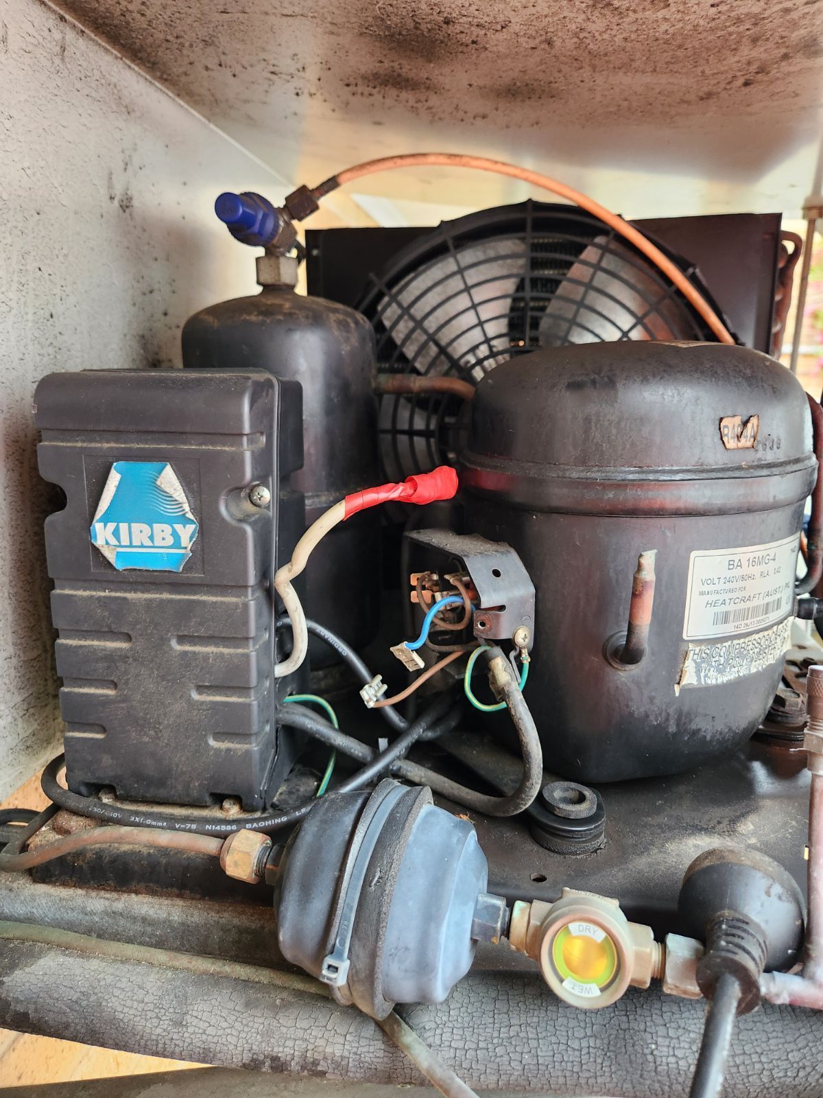 Kirby vacuum compressor unit inside a dusty machine compartment, with hoses, fan, and motor visible — Deltech HVACR in Georgetown, NSW