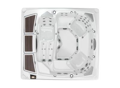 Overhead view of a white, square hot tub with multiple seating areas and jets. Brown footrests are on one side.
