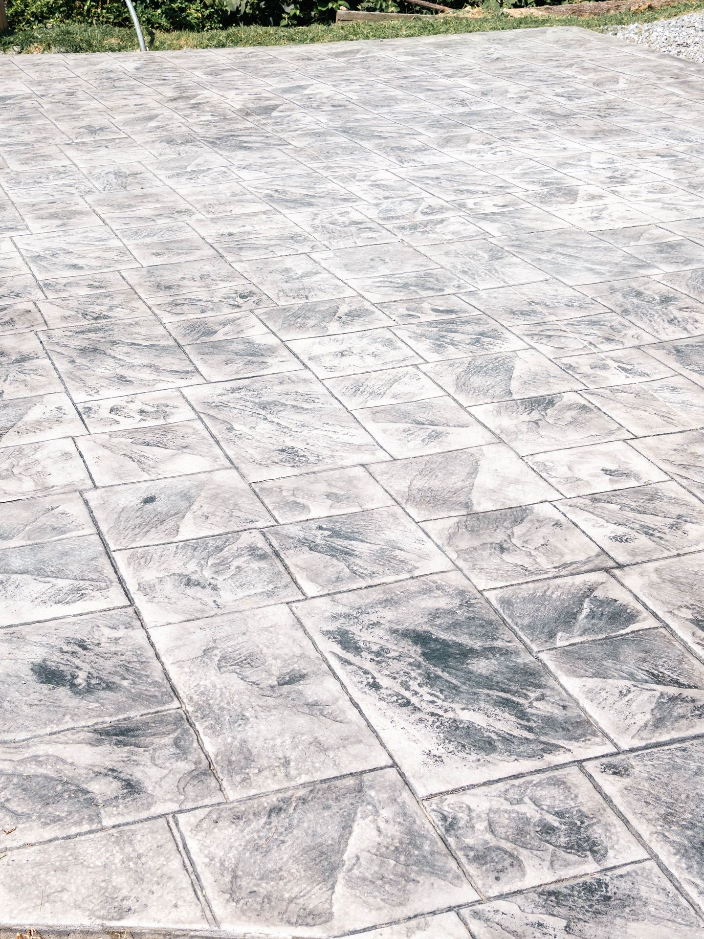 Textured gray concrete patio with rectangular pattern.