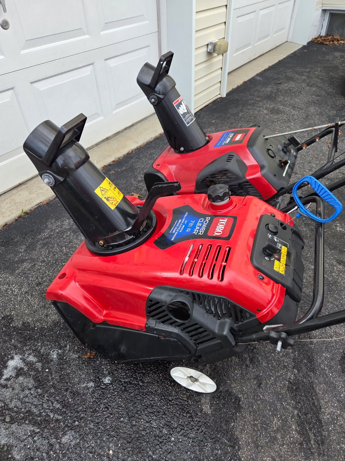 A red pickup truck with a red spreader attached to its rear.