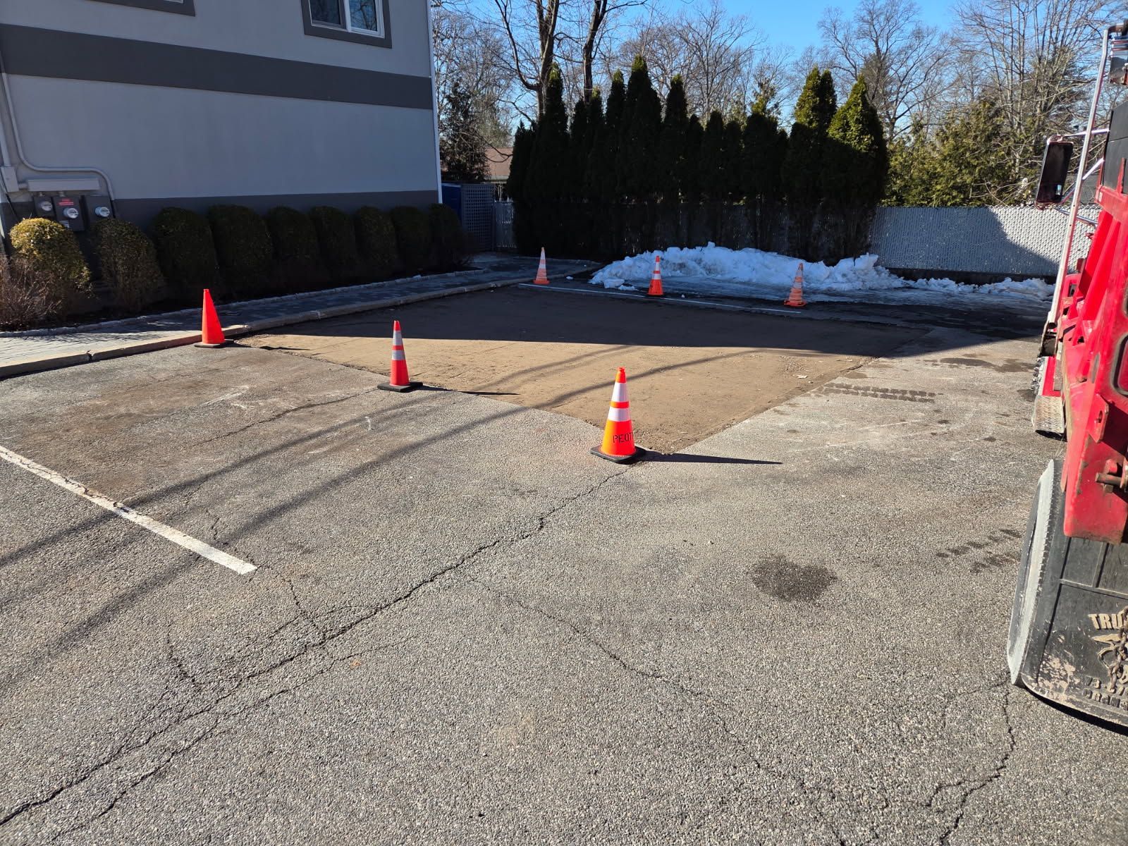 A paved driveway leading to a two-car garage. The garage doors are white, and the driveway is dark asphalt.