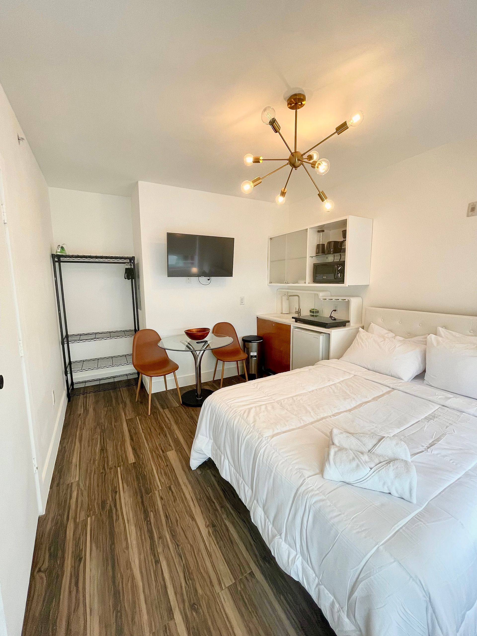 Small studio apartment with bed, kitchen, TV, and seating area.
