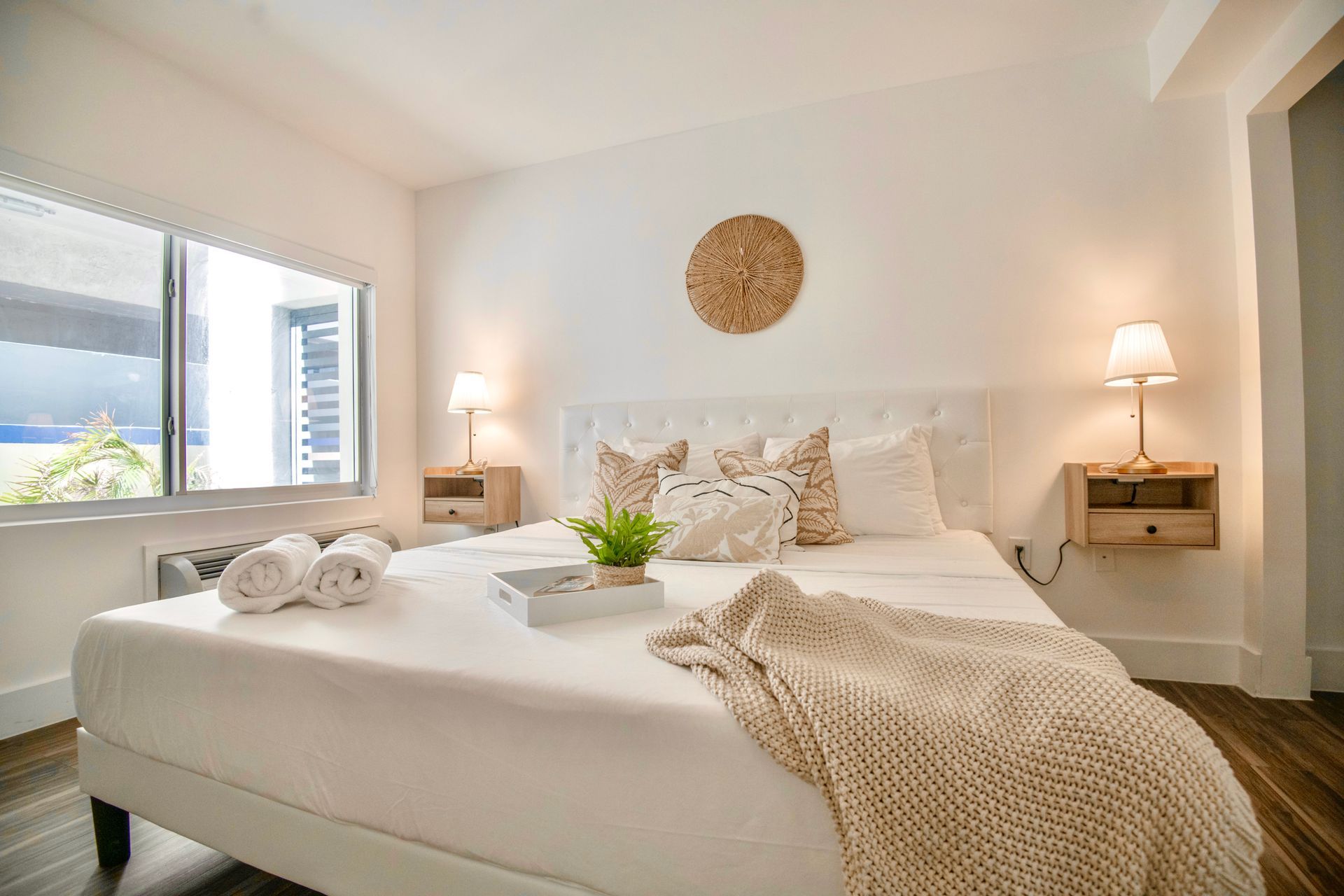 Bedroom with a white bed, wooden nightstands, and decorative pillows.