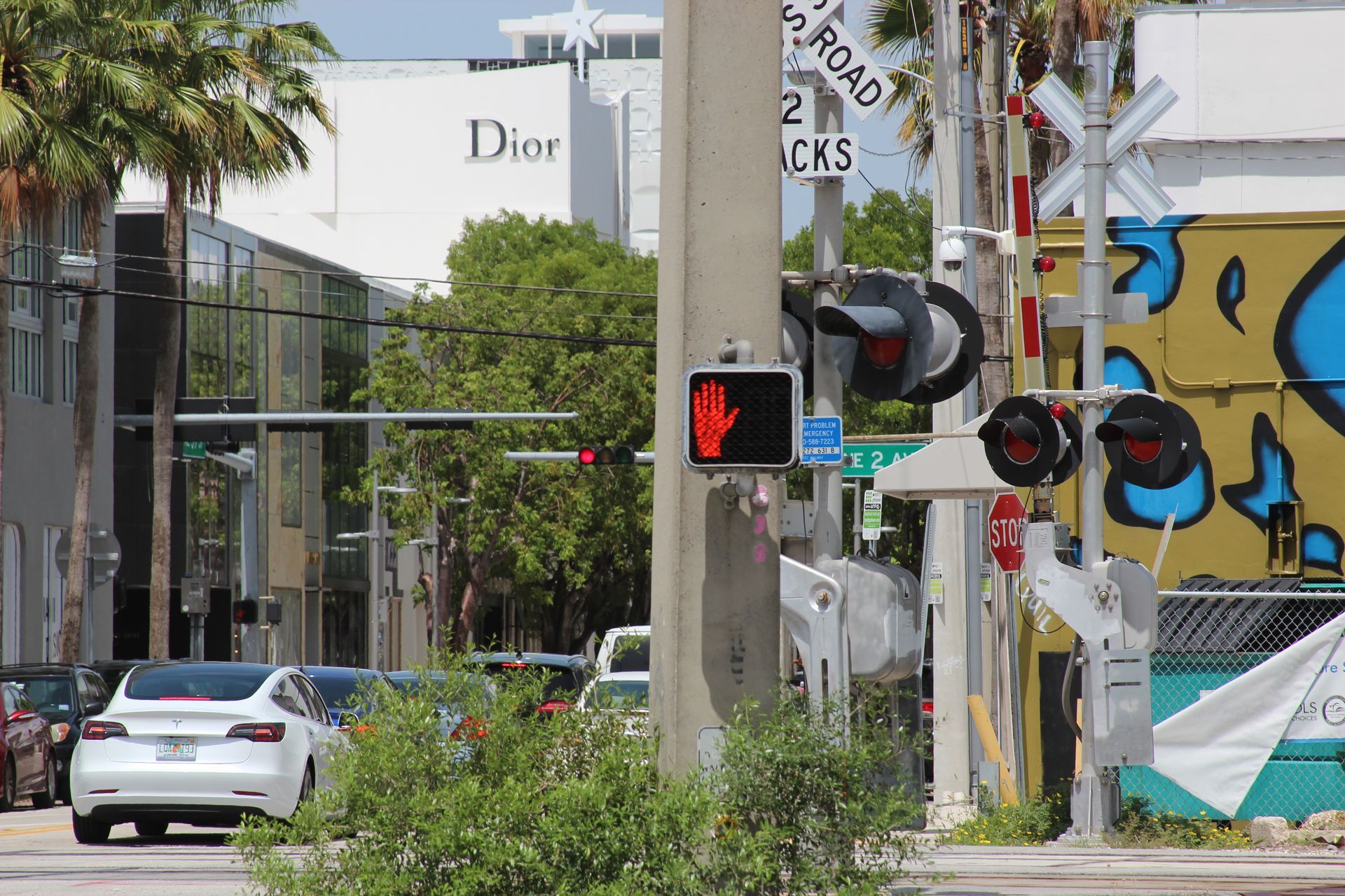 Street scene: railroad crossing with red lights on. A red 
