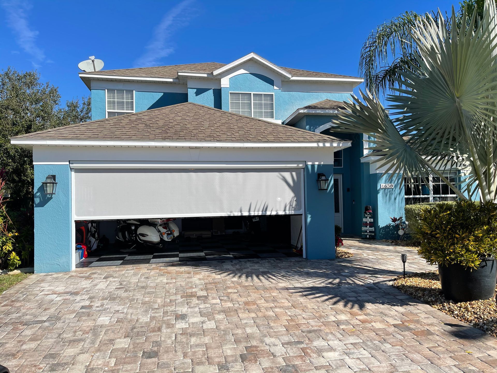 A blue house with a motorized patio screen