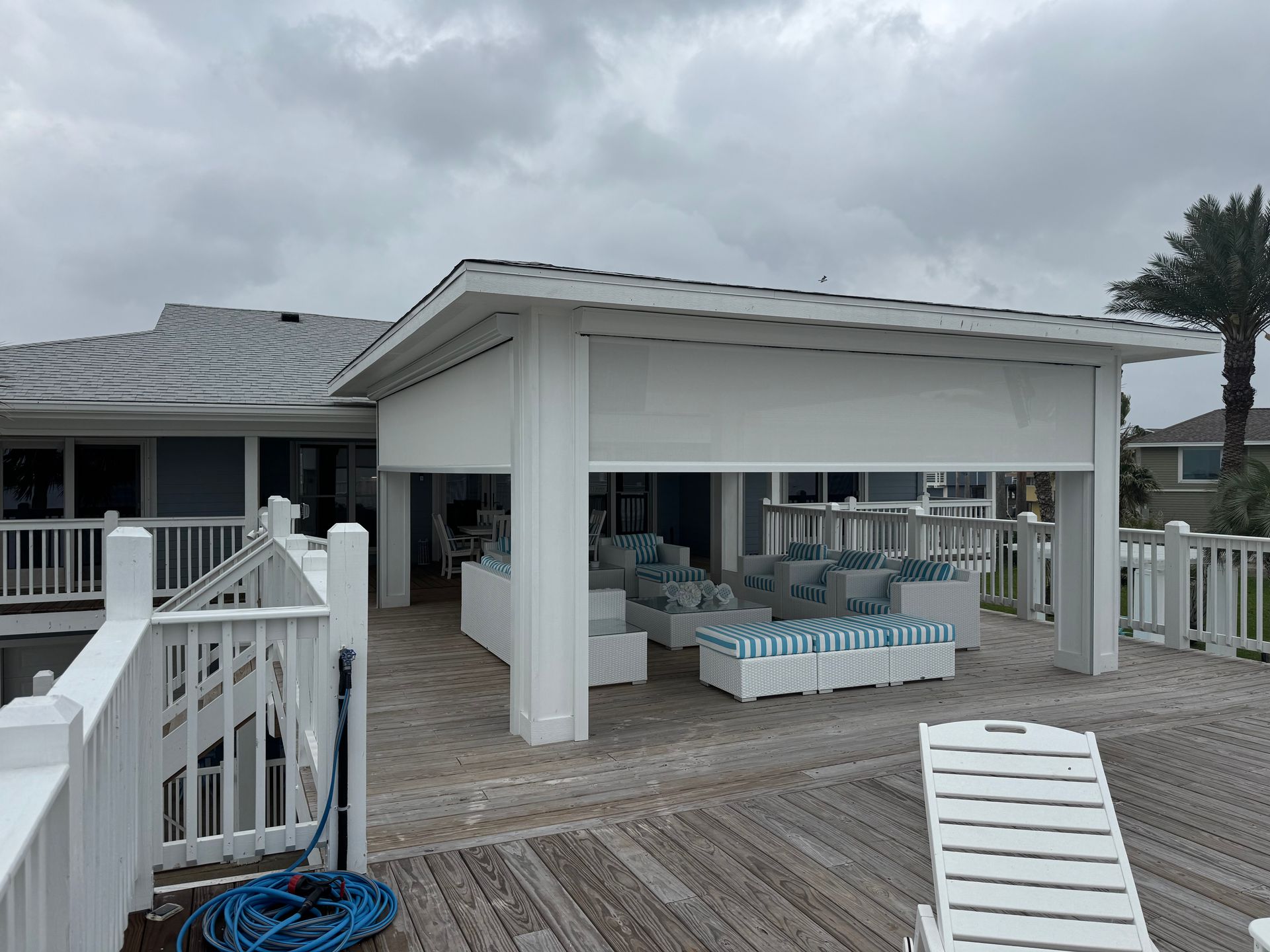 A white house with a white fence and a wooden deck
