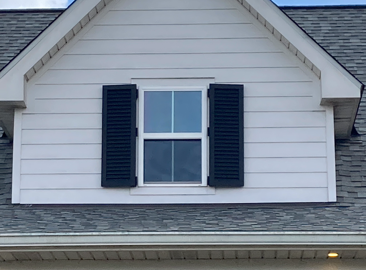 A white house with black shutters and a window
