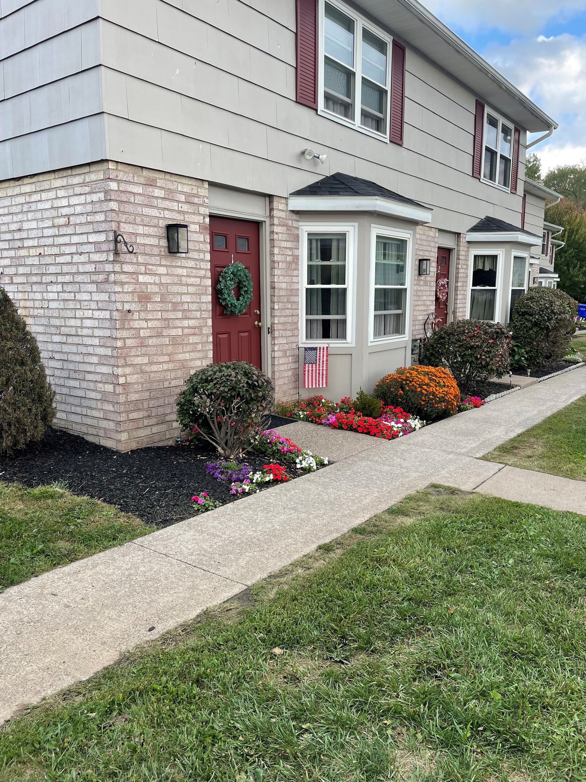 Kitchen with wood cabinets, white appliances, and a doorway to another room.
