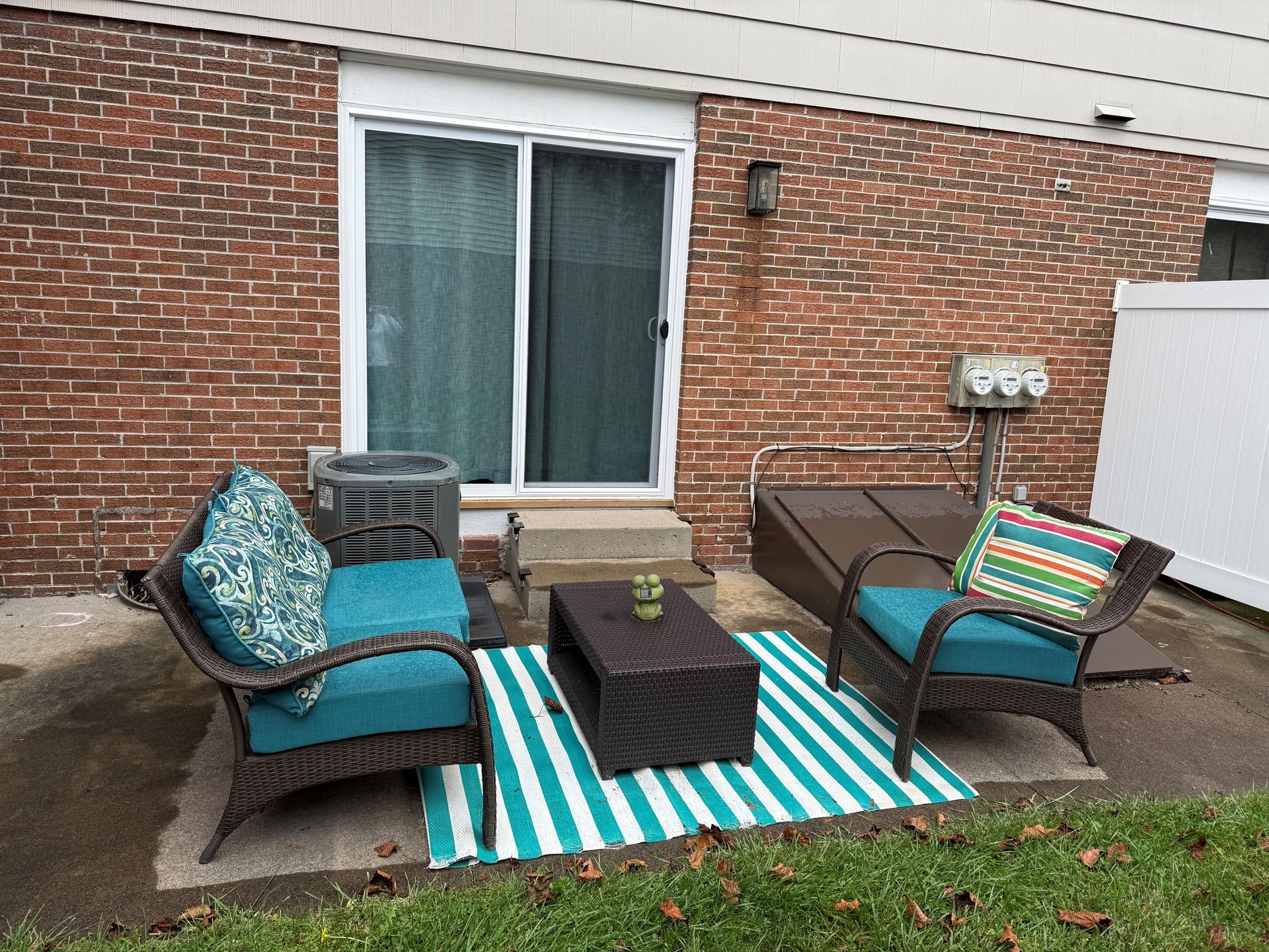 Playground in front of apartment buildings; cars parked nearby. Green grass and wood chips on the ground.