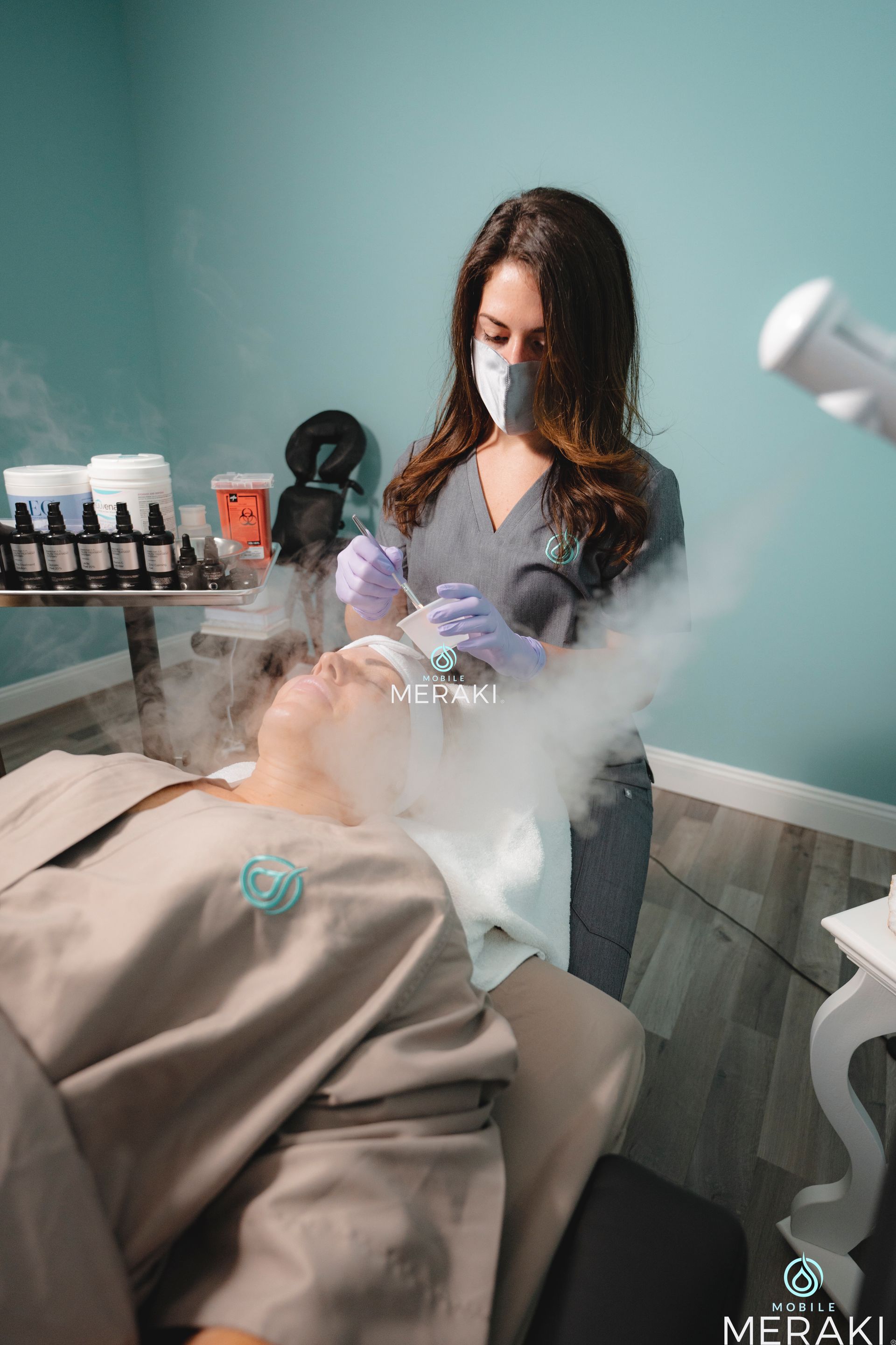 A woman is giving someone a facial treatment at Meraki Integrative Wellness and Medspa