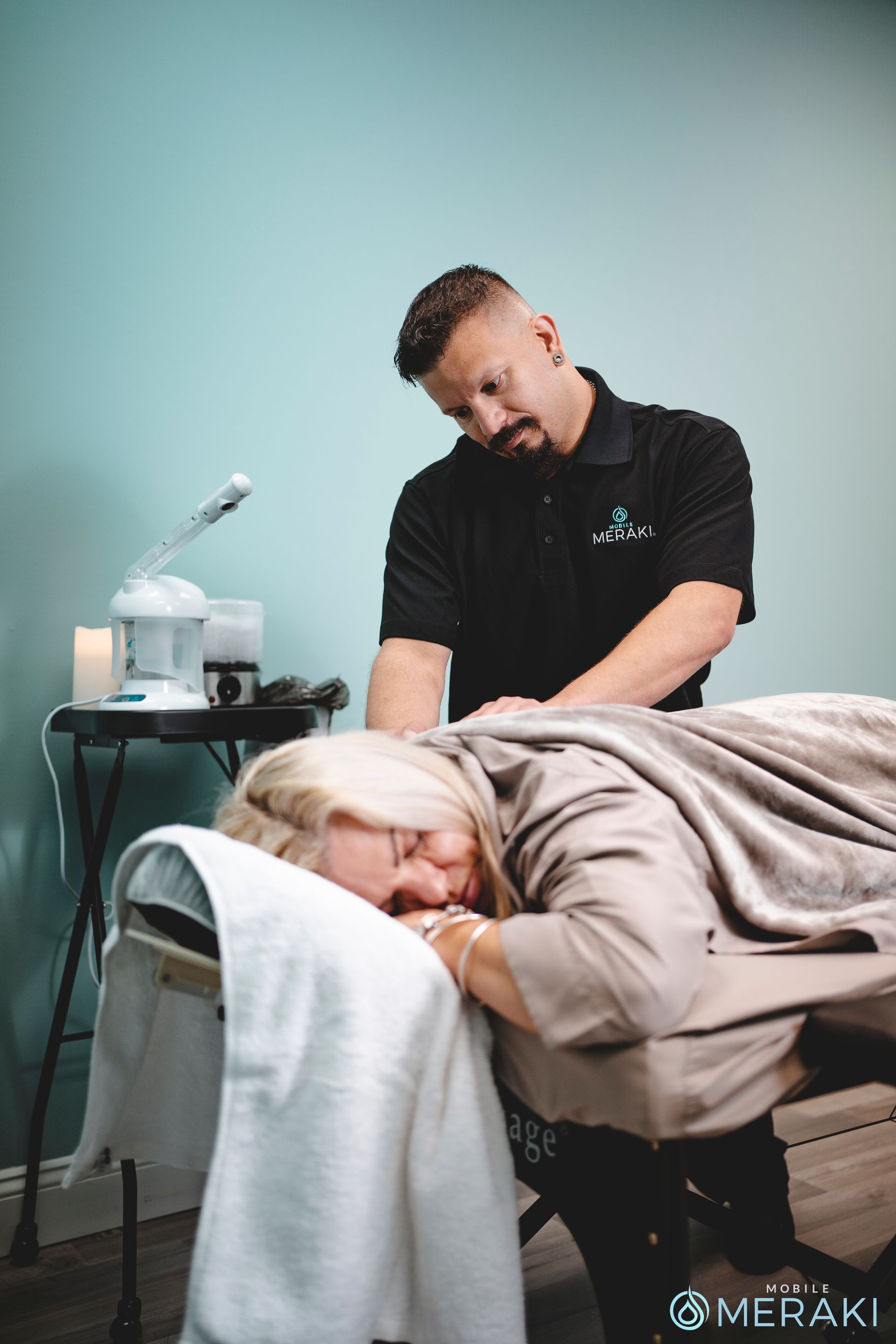 A man is giving a woman a massage in a chair at Meraki Integrative Wellness and Medspa