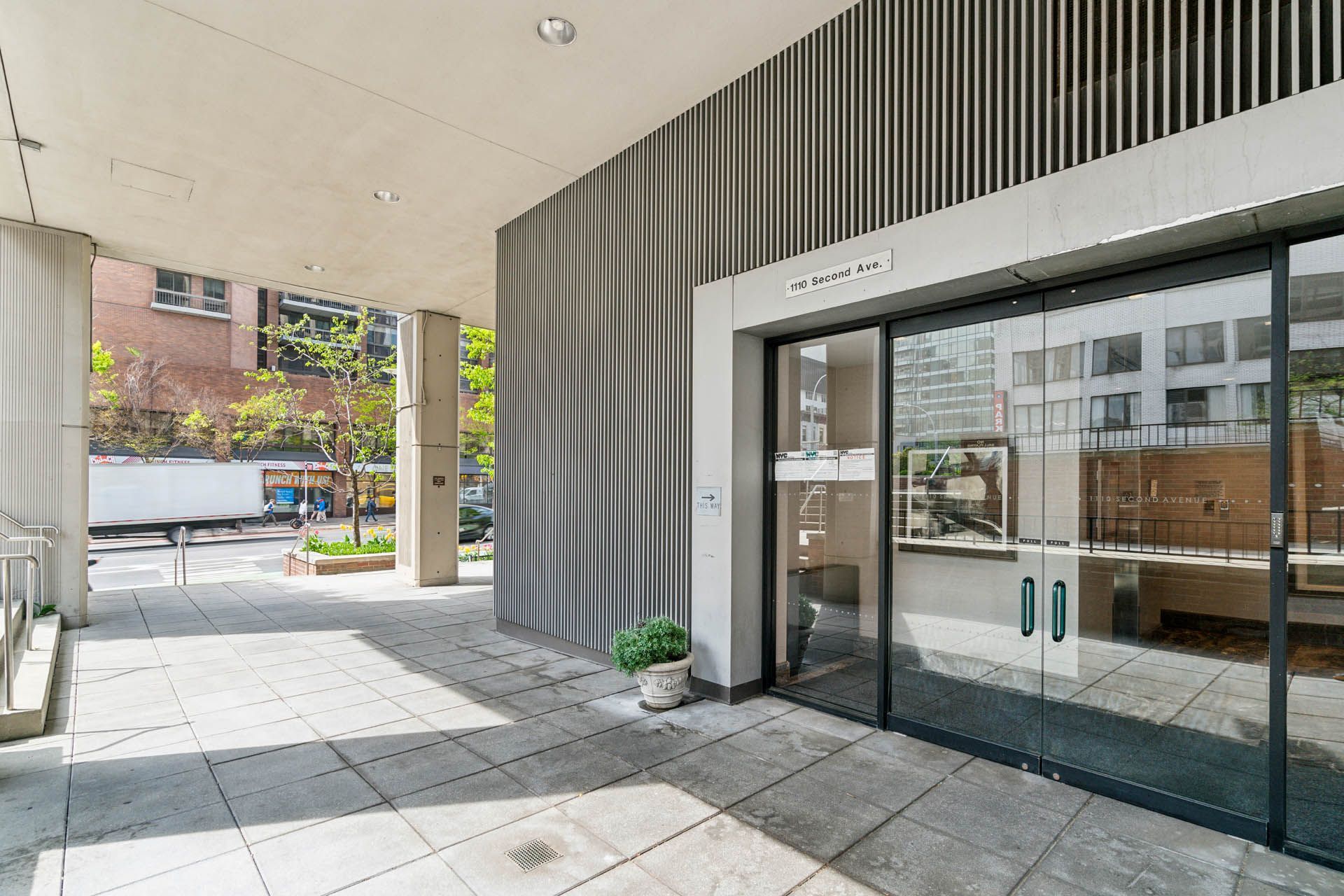 A large building with a sliding glass door and a walkway leading to it.