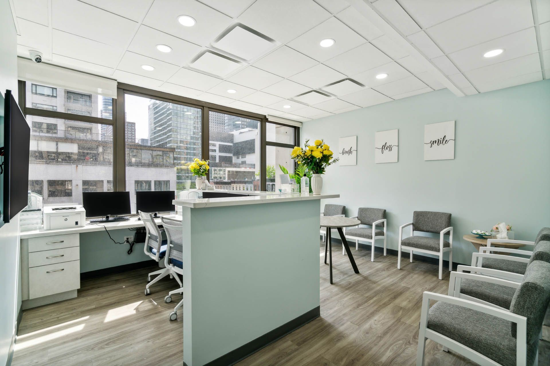 A waiting room with a desk , chairs , and computers.
