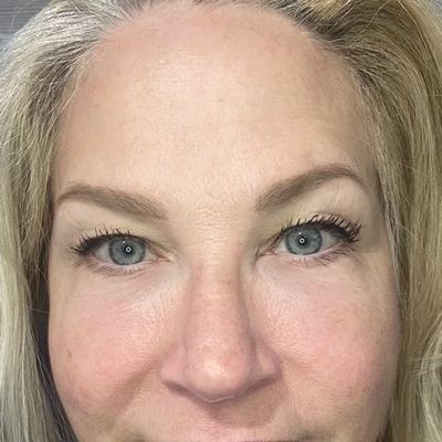 A close up of a woman 's face with blue eyes and blonde hair.