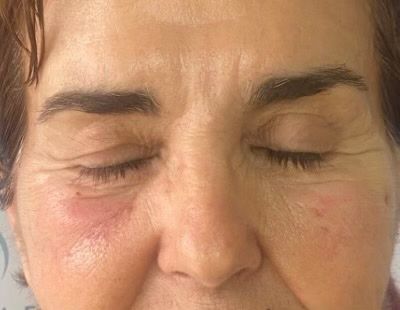 A close up of a woman 's face with her eyes closed.