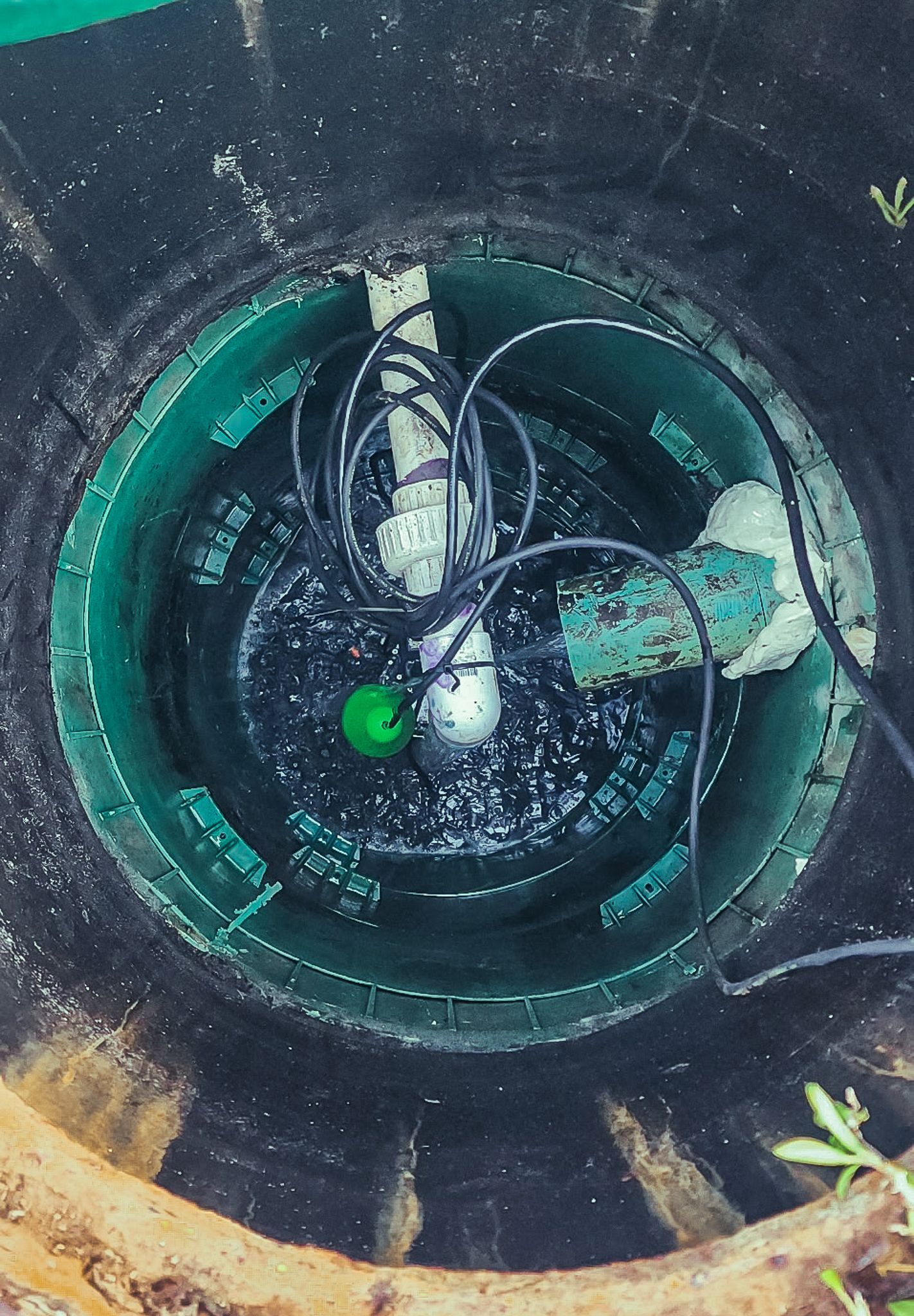 The inside of a manhole cover with a green button on it.
