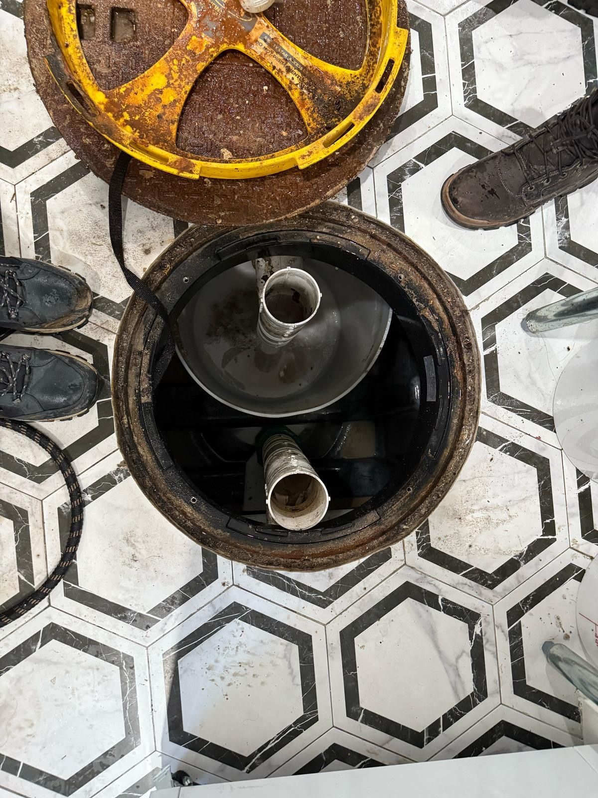 A manhole cover is sitting on top of a tiled floor.