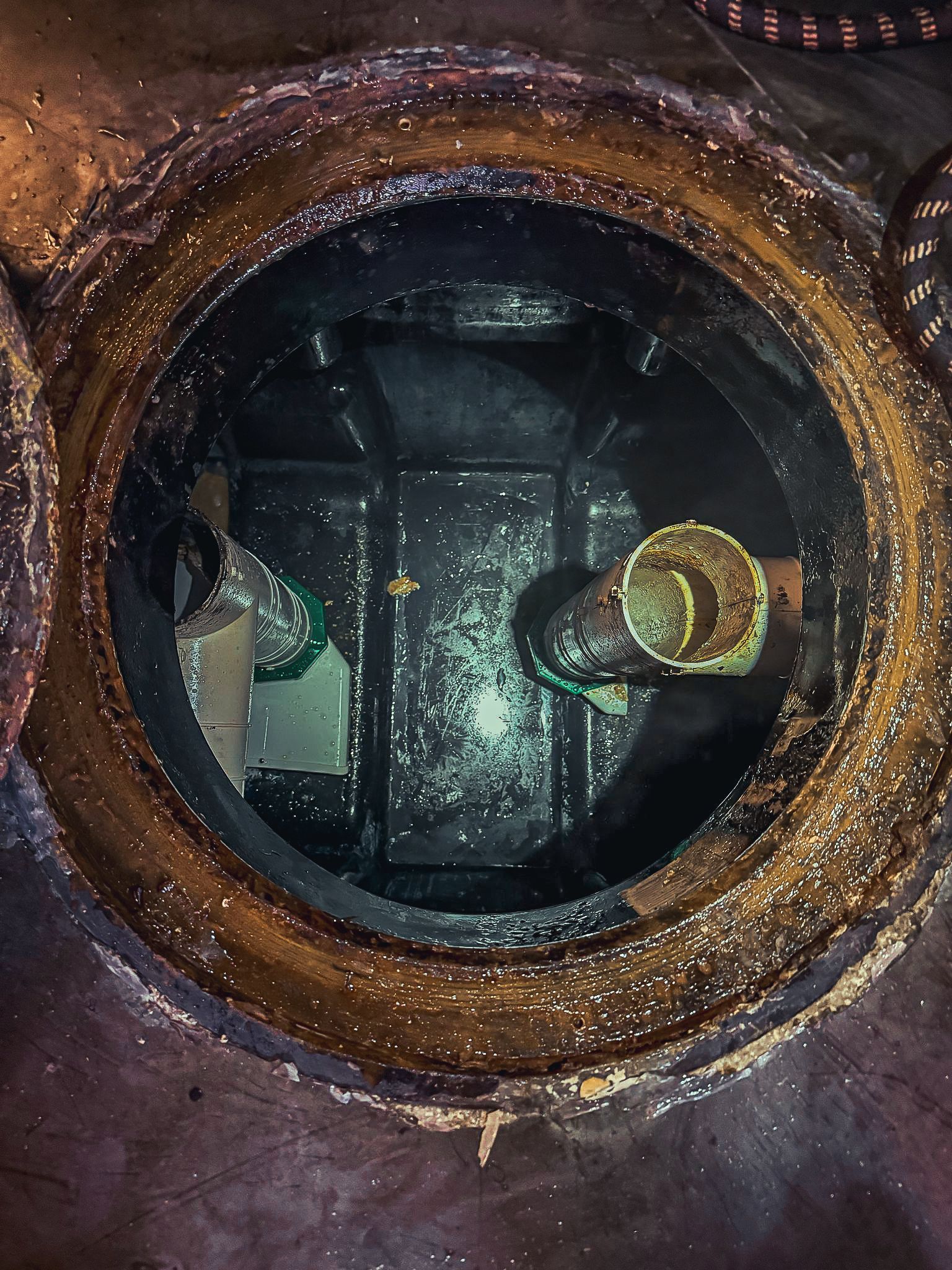 A close up of a manhole cover with a reflection of a person in it.