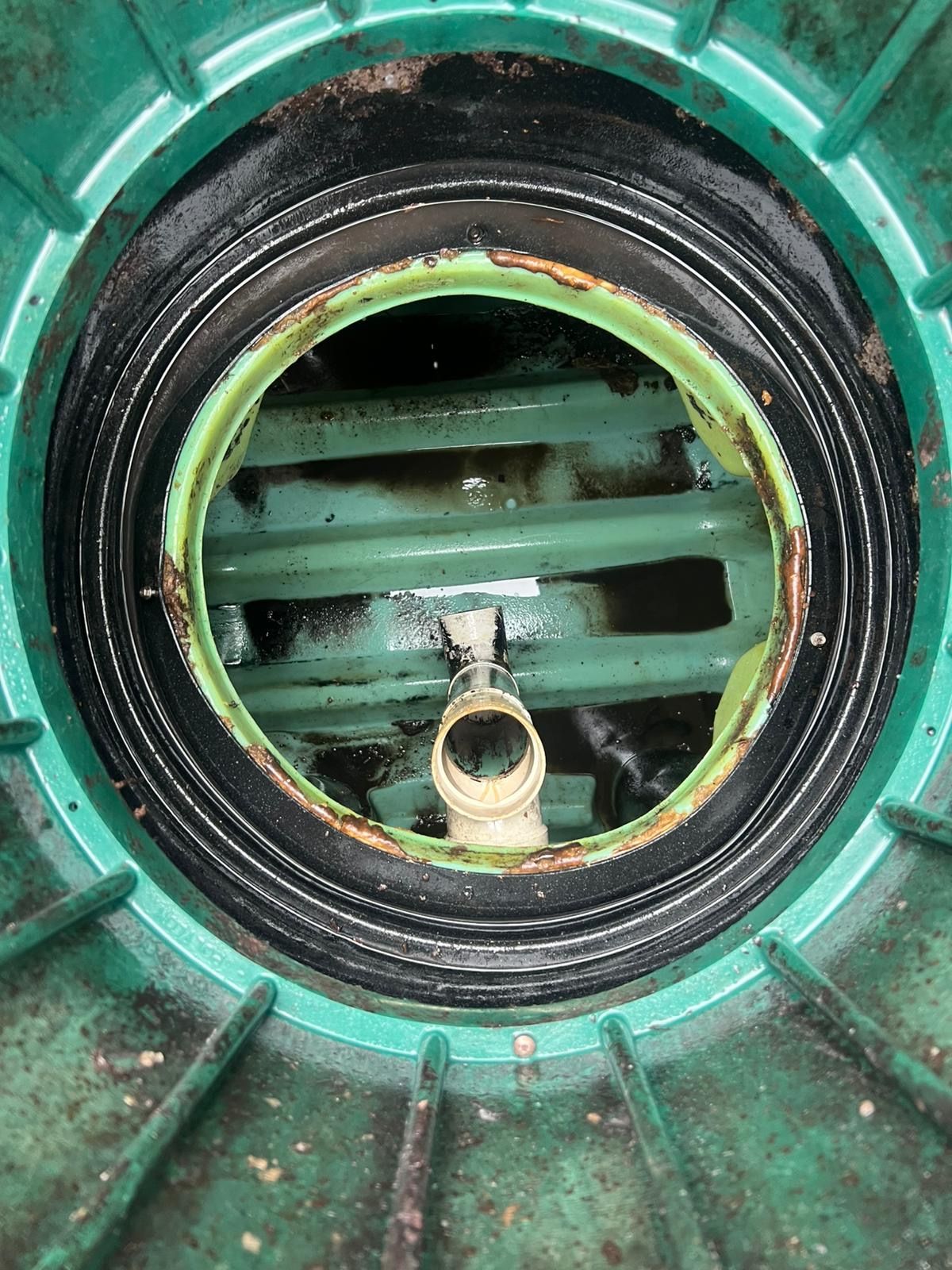 A close up of a green drain with a hole in the middle.