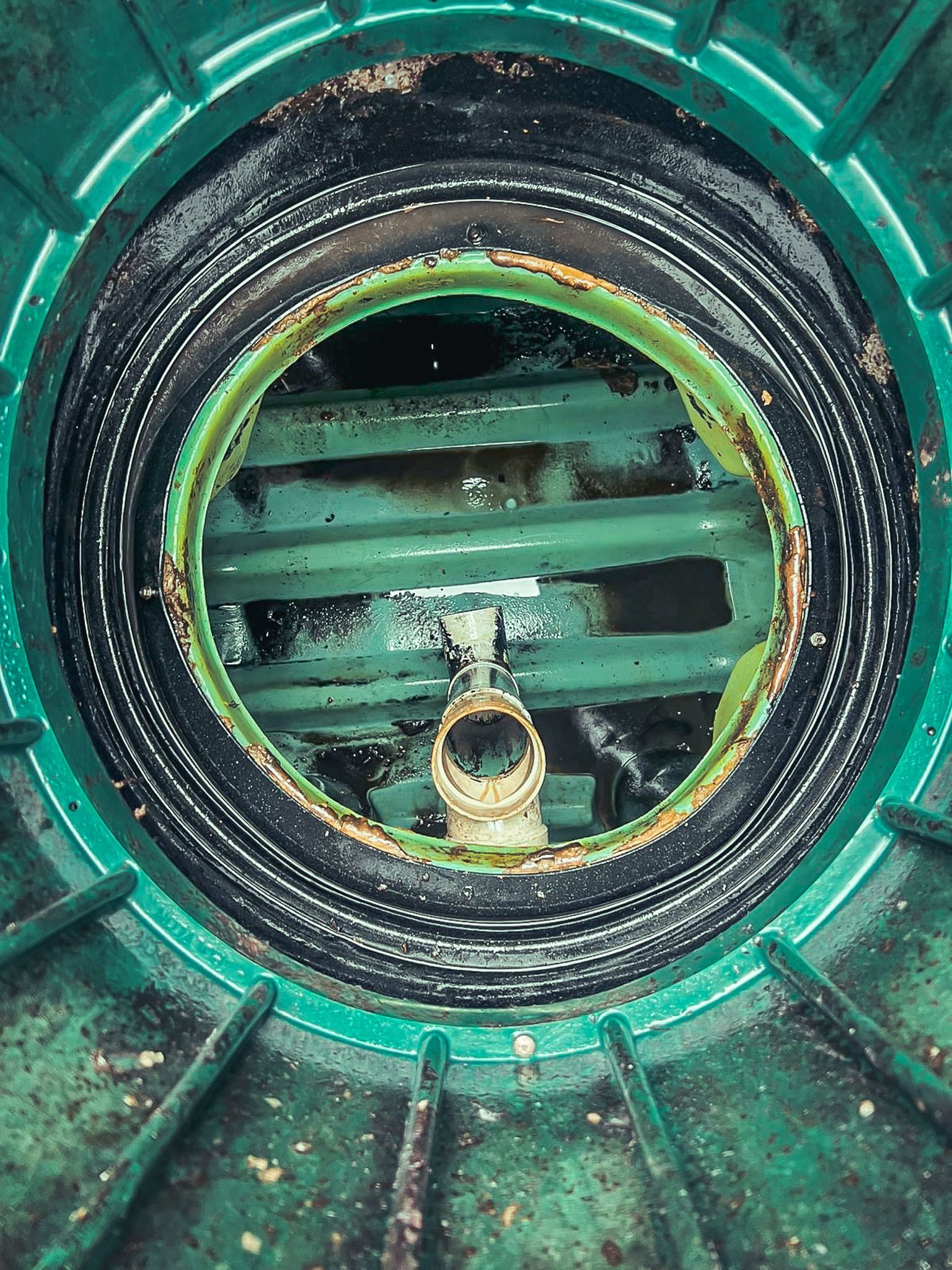A close up of a green drain with a hole in the middle.