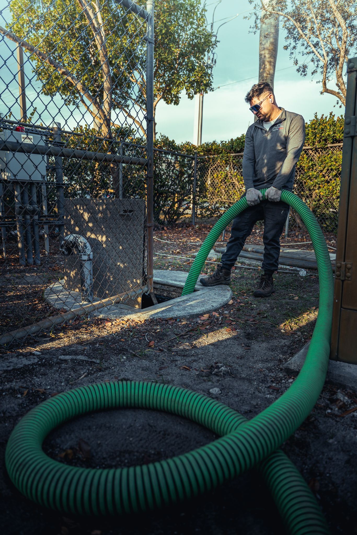 A man is standing next to a green hose.