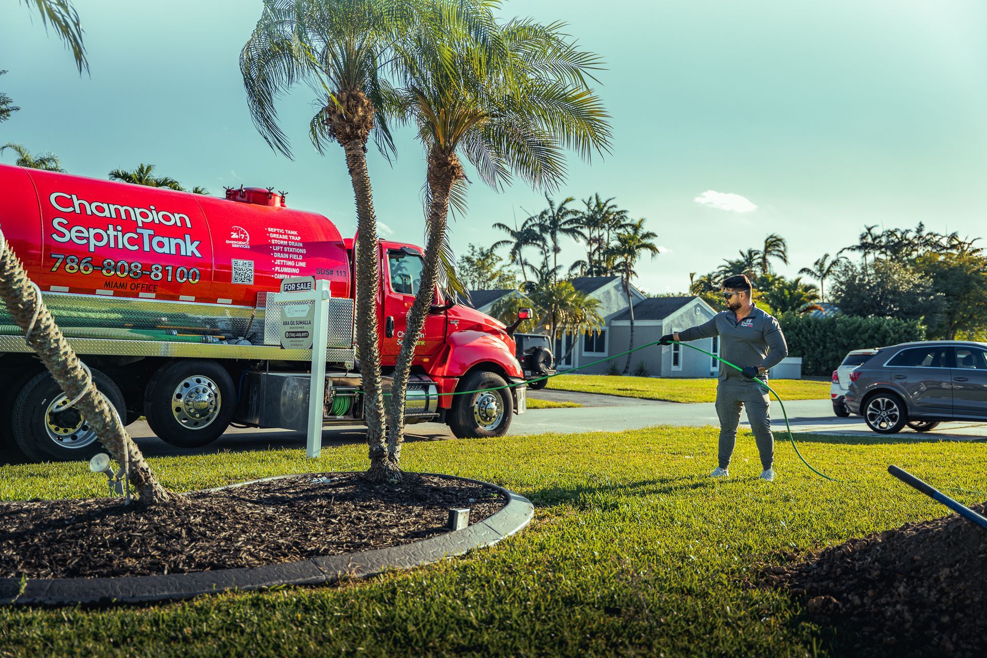 A man is standing in front of a septic tank in a yard.