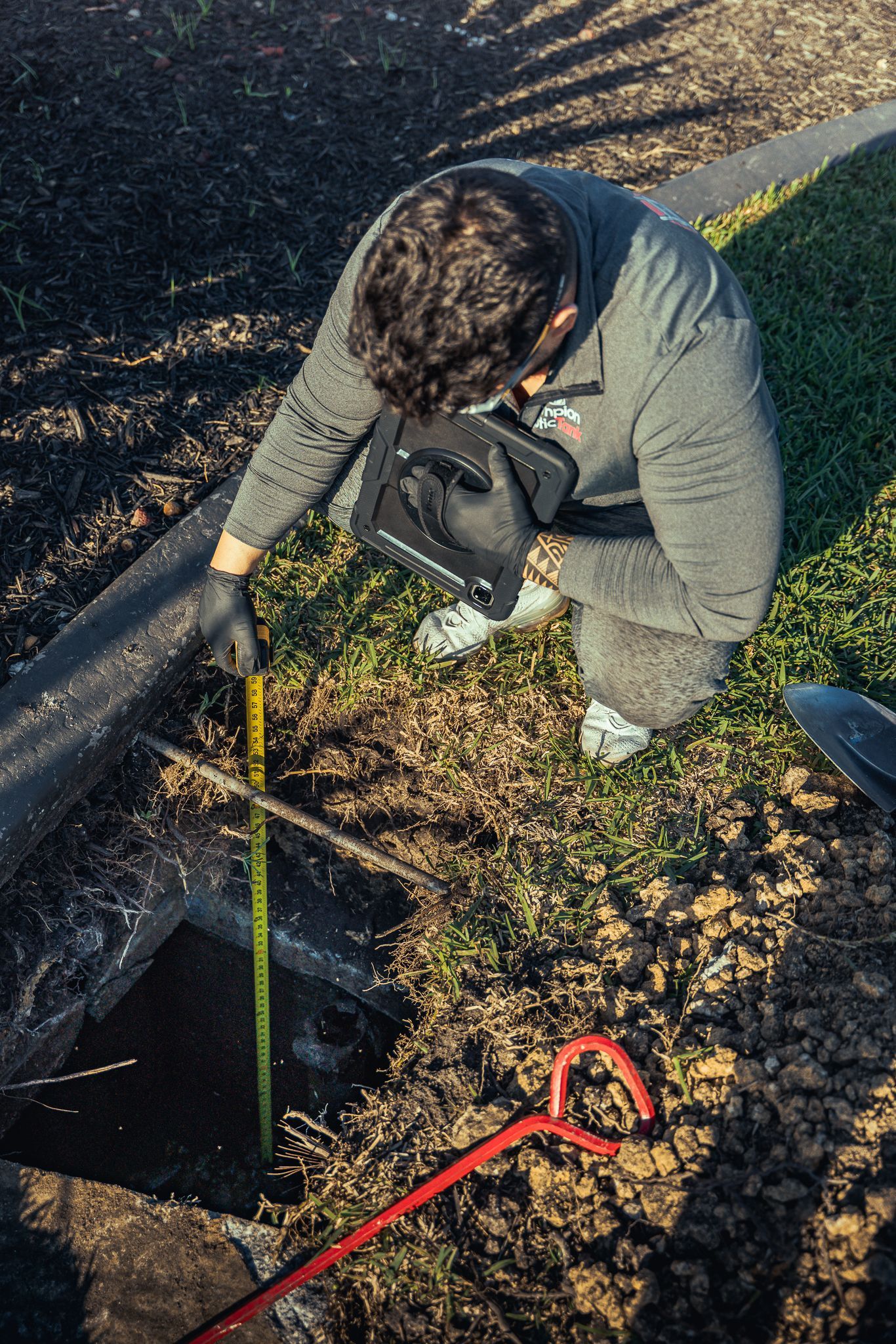 A man is measuring a pipe with a tape measure.