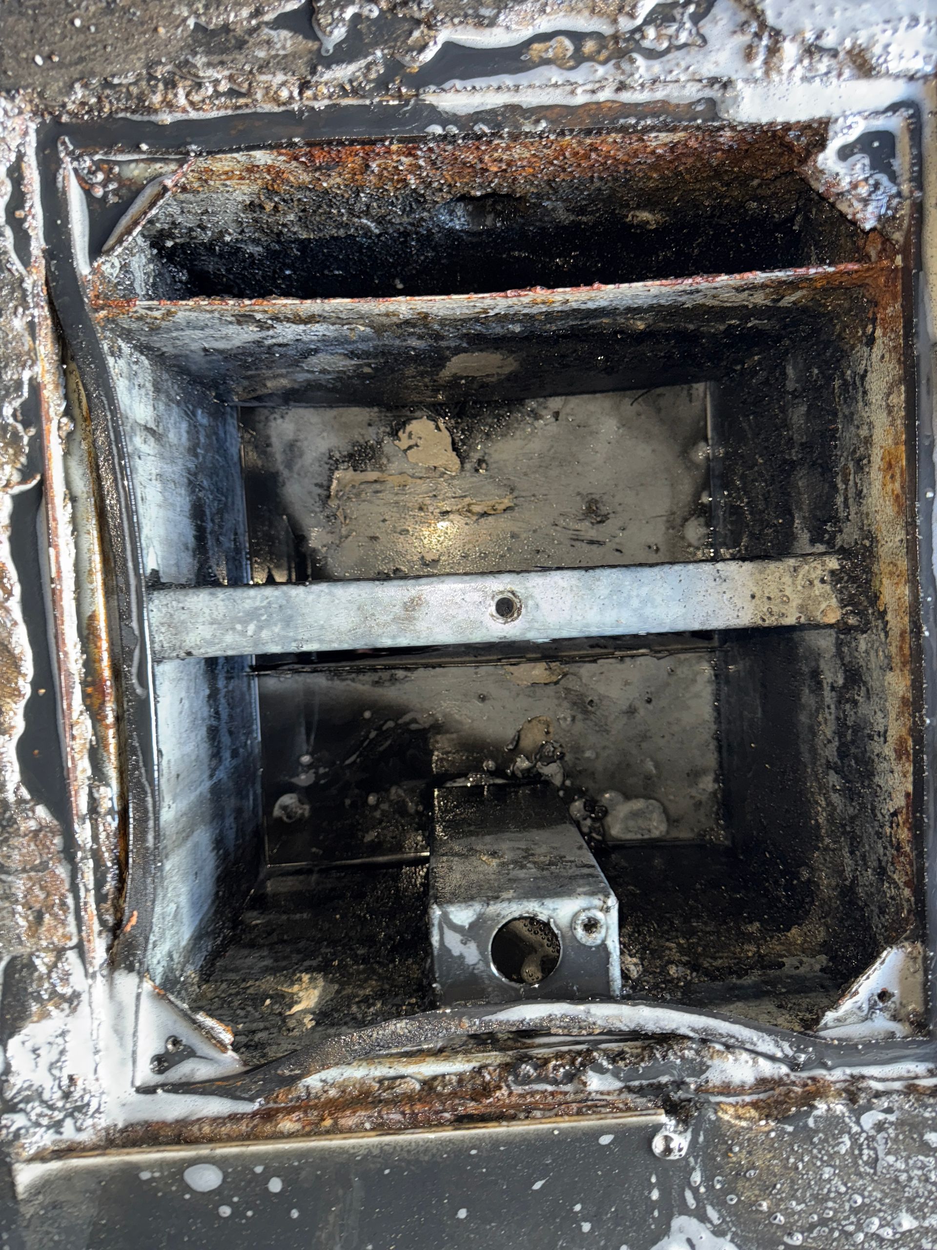 A rusty metal box with a hole in the middle of it.