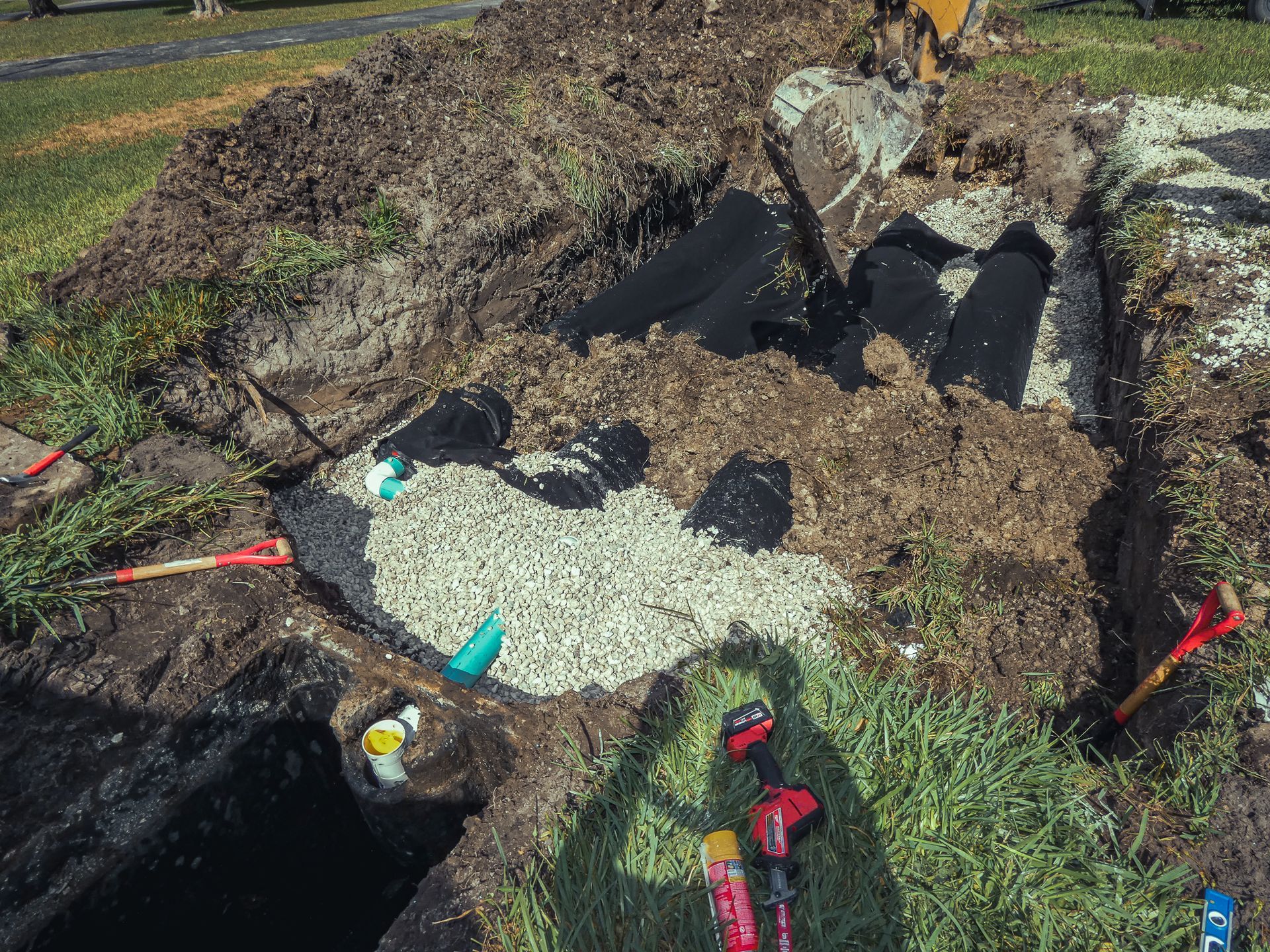 A pile of dirt and rocks is sitting on top of a grass covered field.