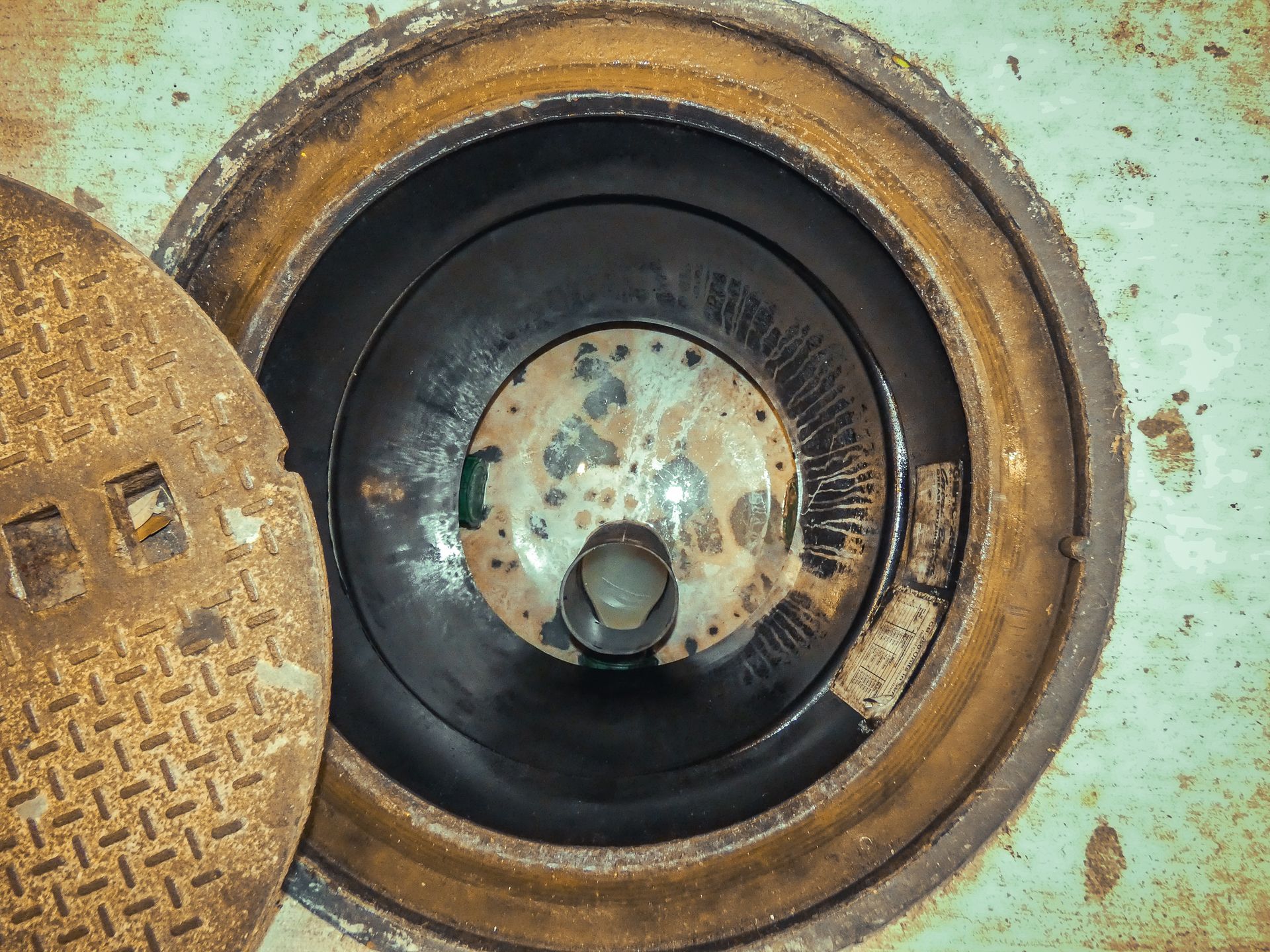 A close up of a manhole cover with a hole in it.