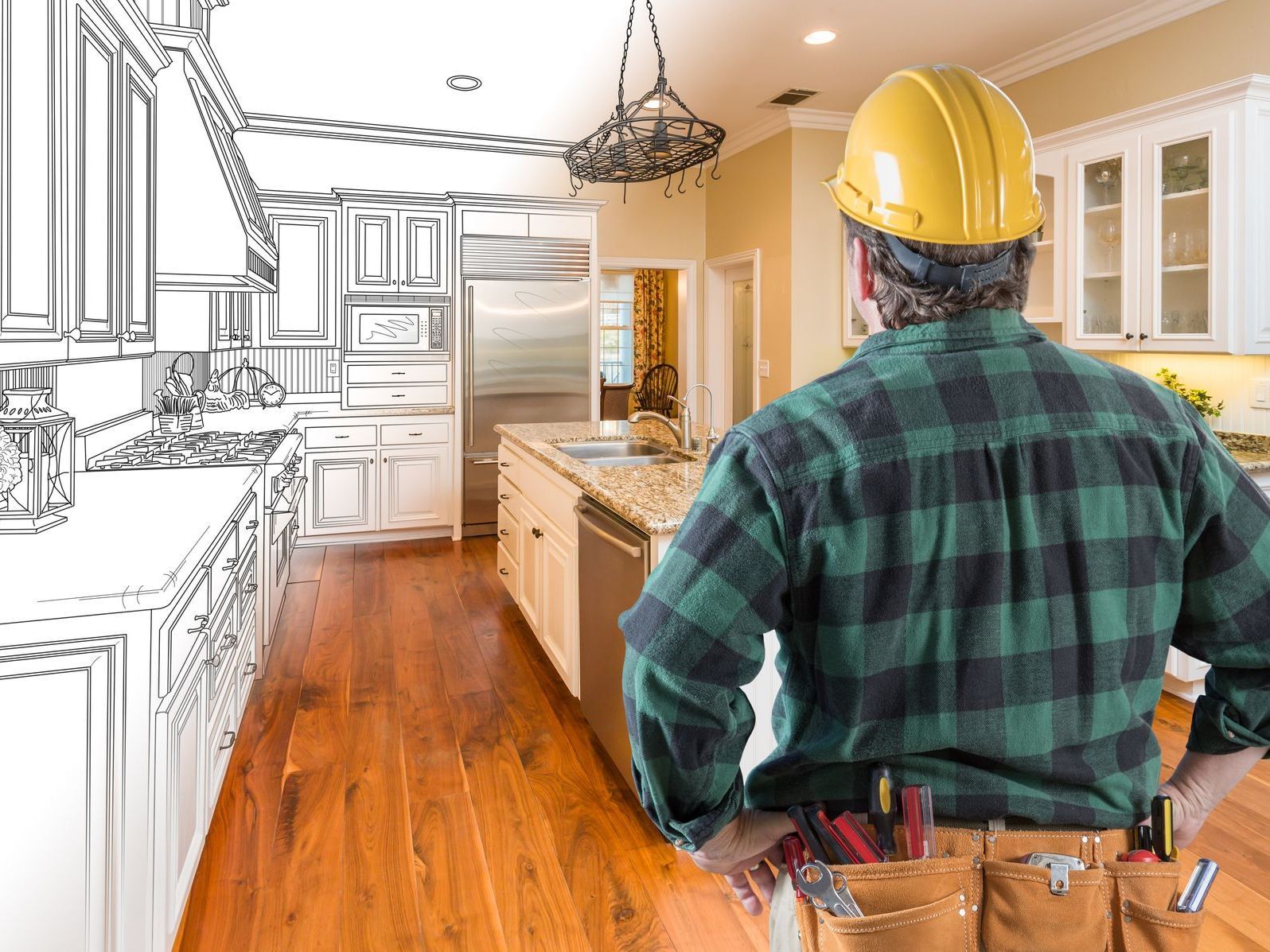 A man wearing a hard hat is standing in a kitchen with a drawing of the kitchen in the background.