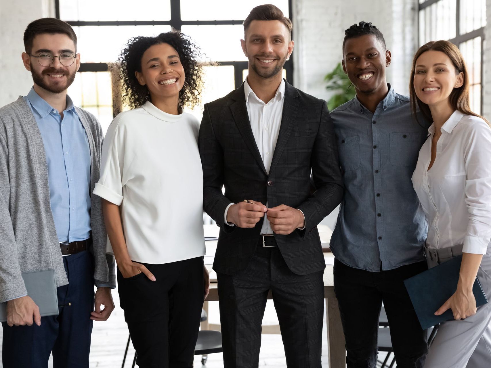 A man wearing a hard hat is standing in a kitchen with a drawing of the kitchen in the background.