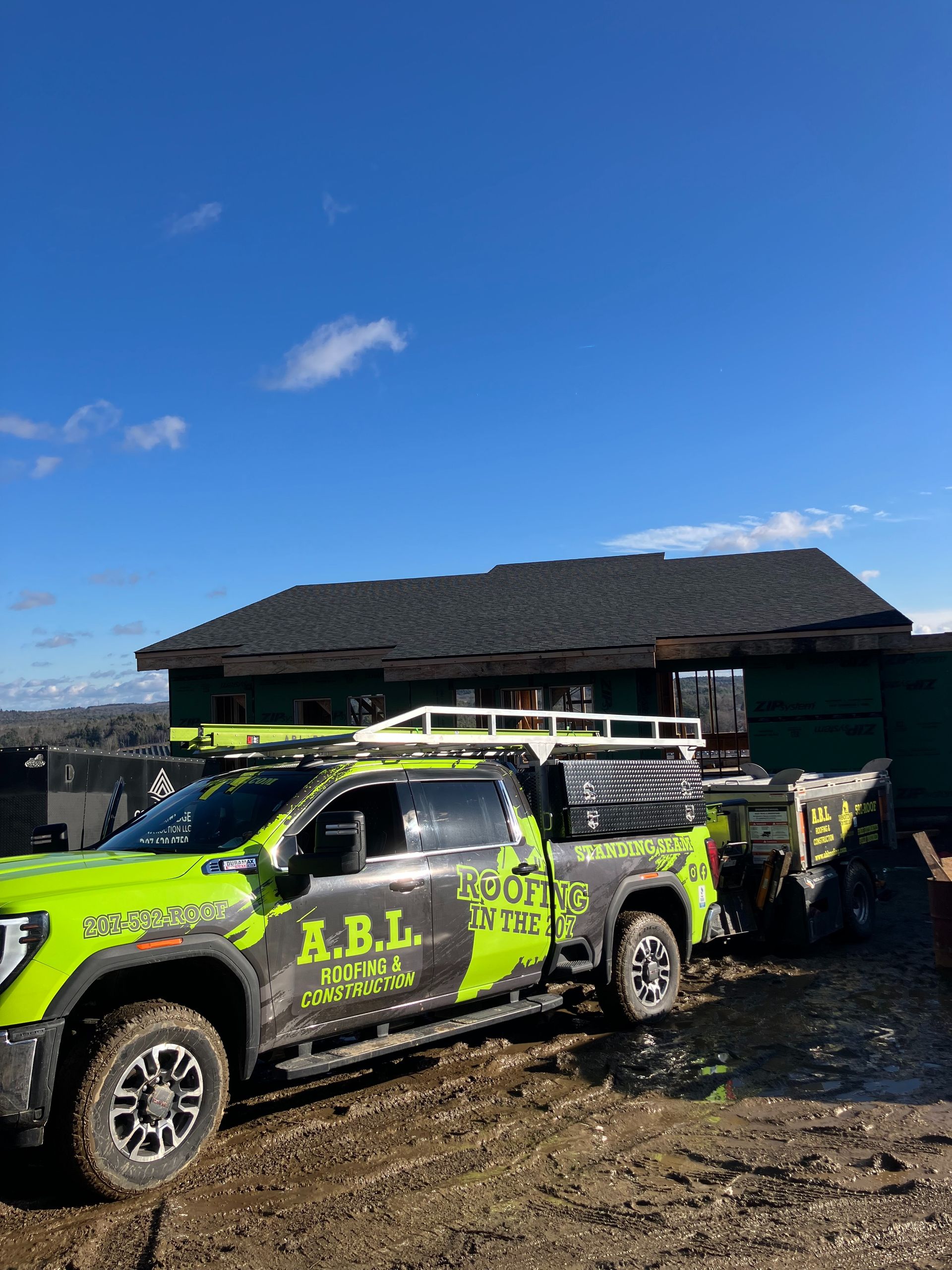 A green truck is parked in front of a house.