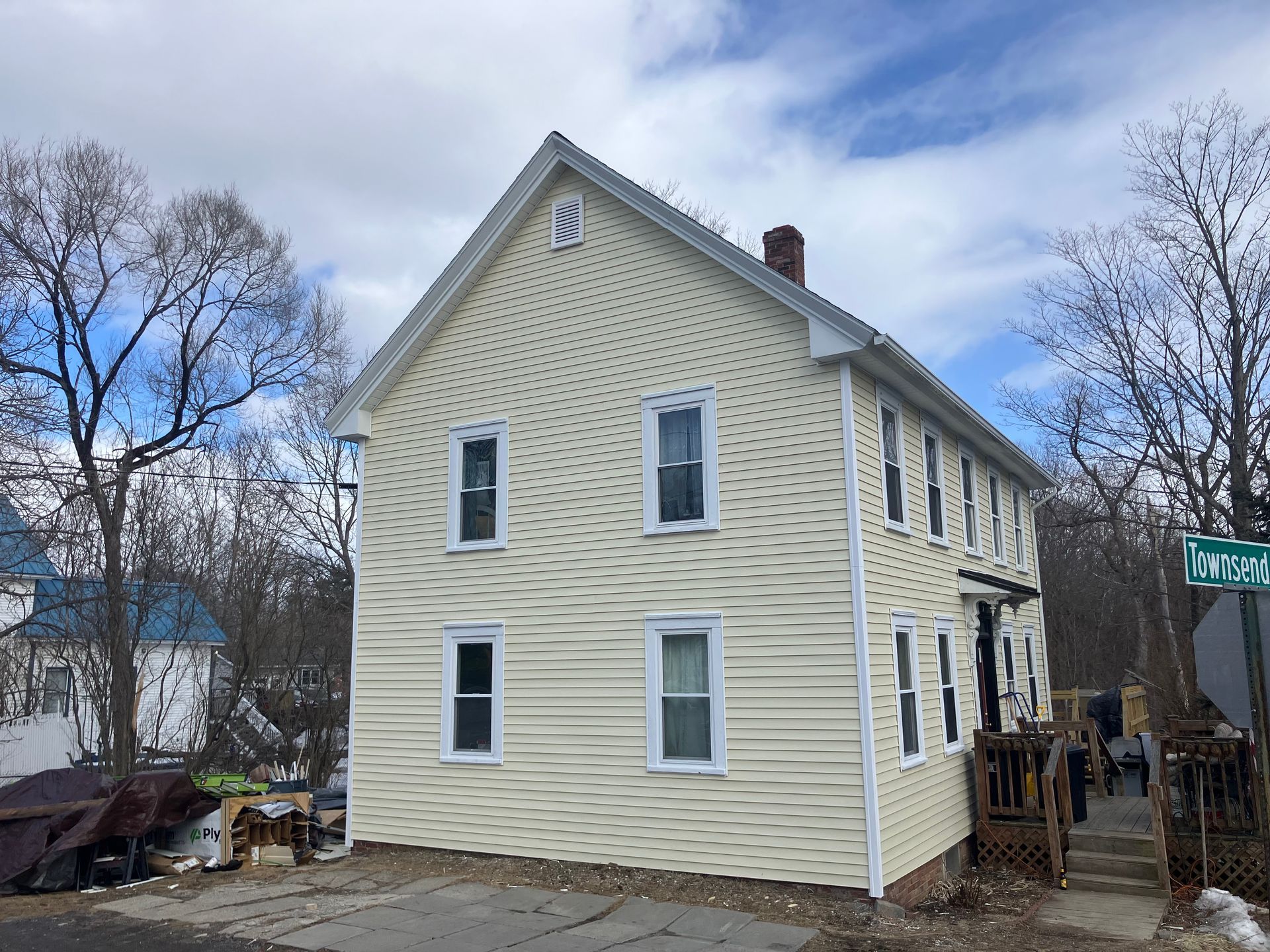 A large white house with a lot of windows is sitting on the side of the road.