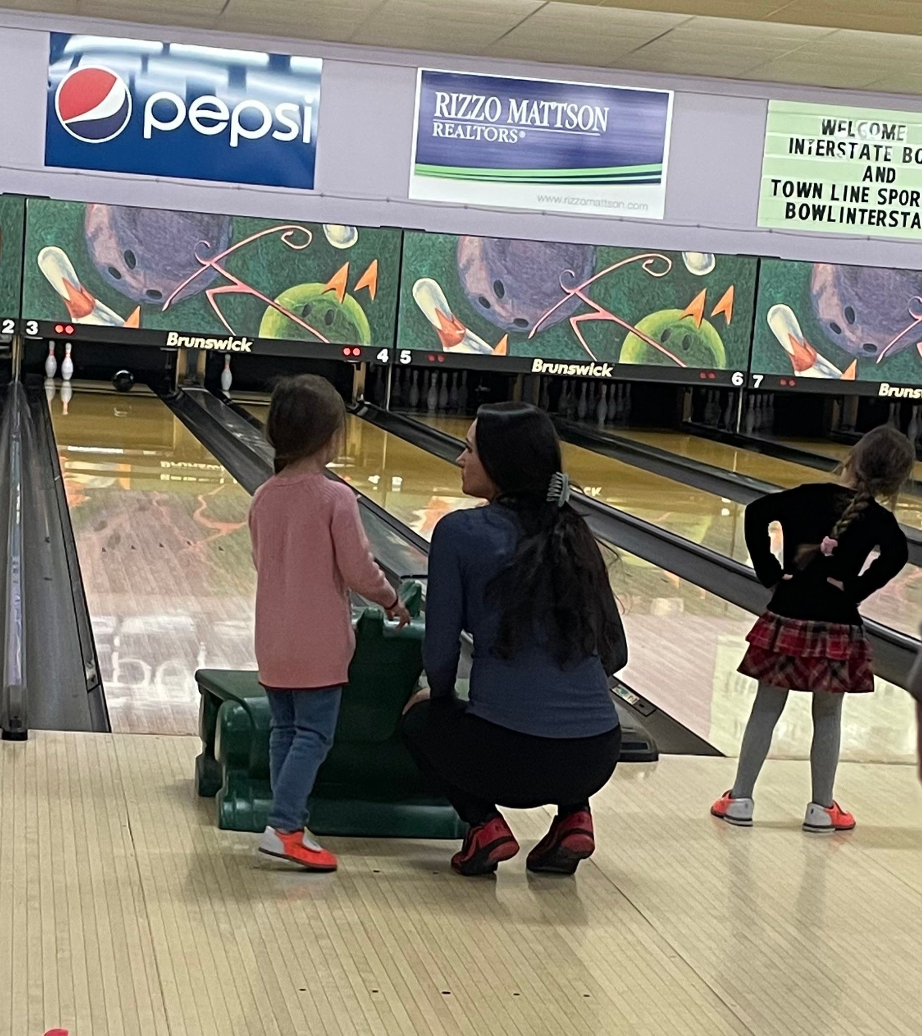 A bowling alley with a pepsi sign on the wall